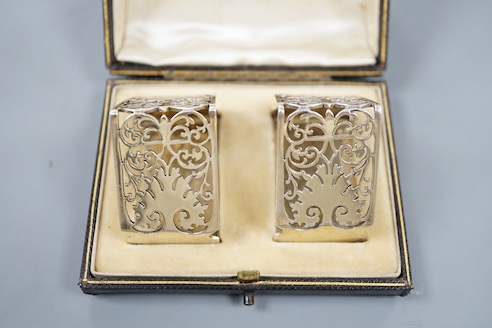 A late Victorian cased pair of pierced silver triangular napkin rings, by Goldsmiths & Silversmiths Co Ltd, London, 1900, with engraved inscription.